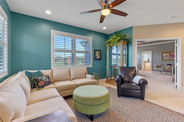 living room featuring carpet, a textured ceiling, and ceiling fan