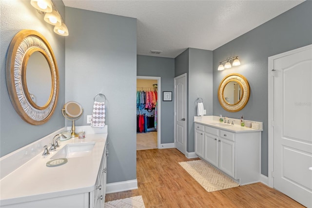 bathroom with vanity, wood-type flooring, and a textured ceiling