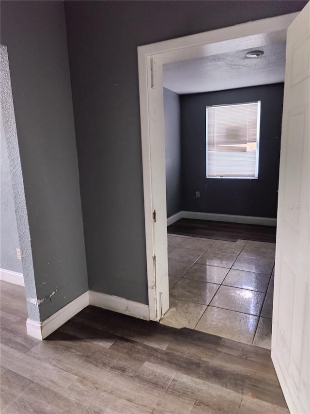 hall with a textured ceiling and hardwood / wood-style flooring