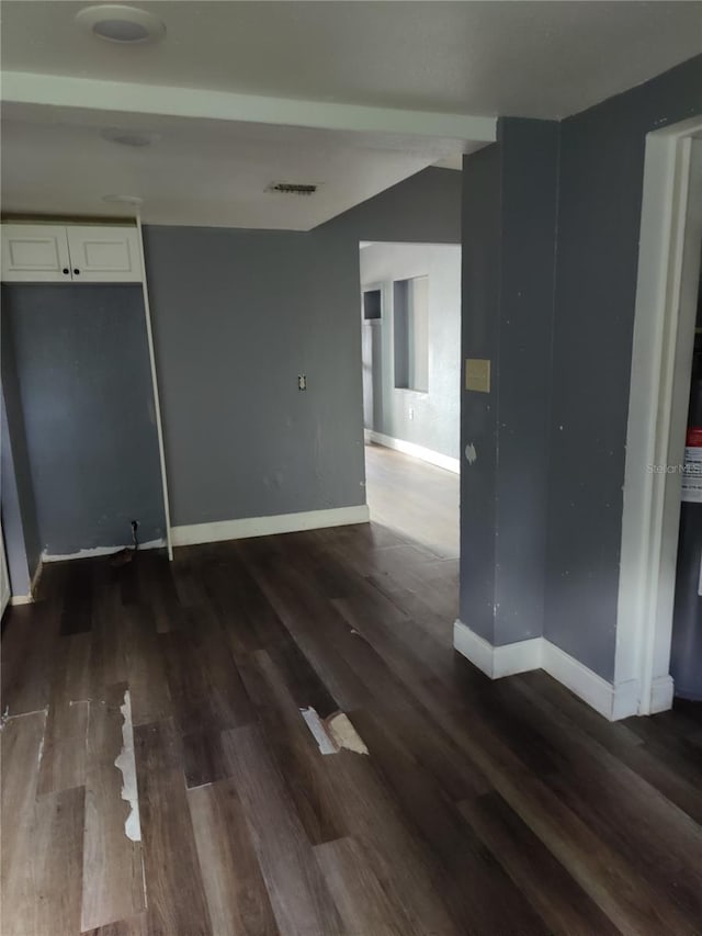 empty room with dark hardwood / wood-style flooring and lofted ceiling