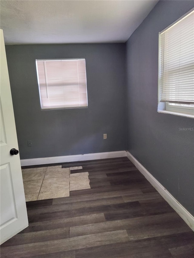 spare room with dark wood-type flooring