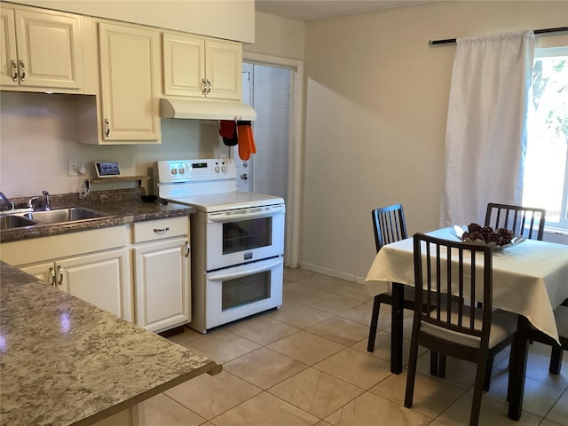 kitchen featuring light tile patterned flooring, electric range, and sink