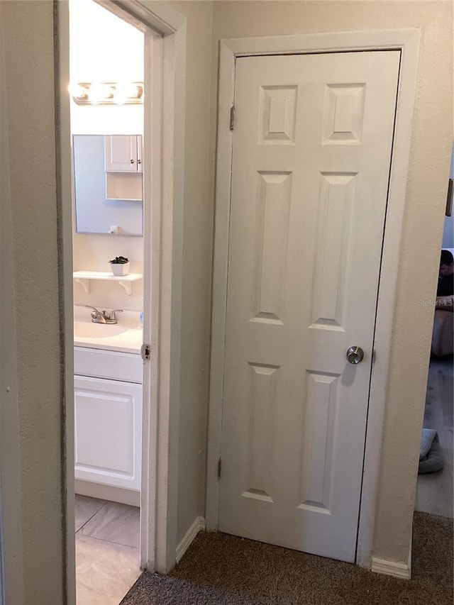 hallway with carpet and sink