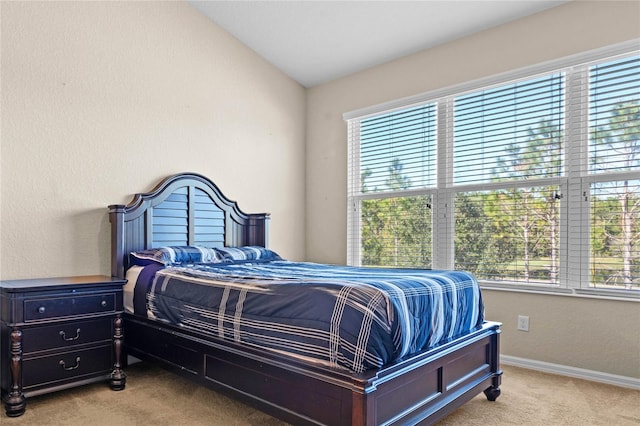 carpeted bedroom with lofted ceiling