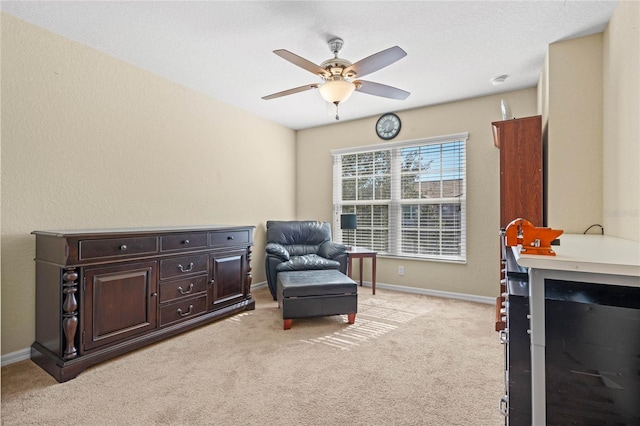 living area with ceiling fan and light colored carpet