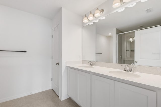 bathroom with a shower with door, vanity, and tile patterned flooring