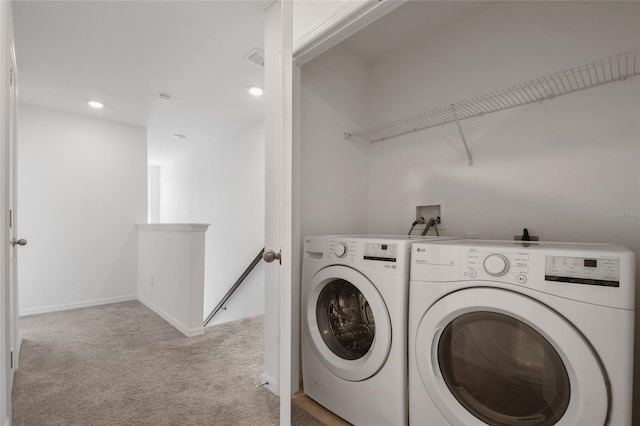 clothes washing area with washer and dryer and light carpet