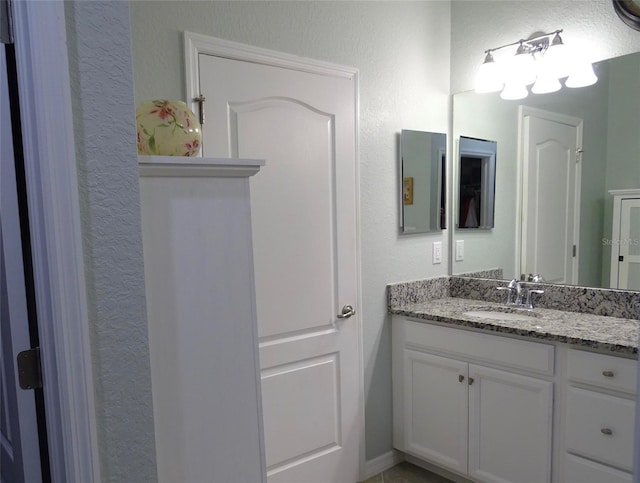 bathroom with a textured wall and vanity