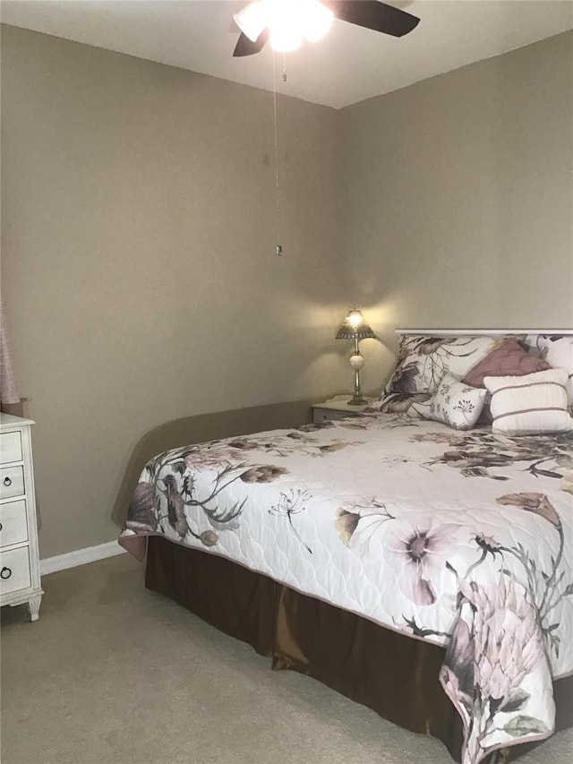 carpeted bedroom with a ceiling fan and baseboards