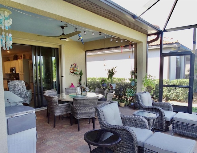 view of patio / terrace featuring glass enclosure, ceiling fan, outdoor dining area, and an outdoor living space