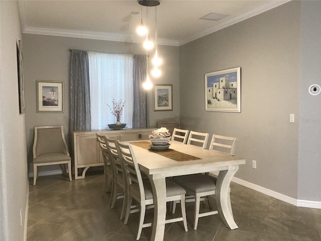 dining area with visible vents, baseboards, crown molding, and dark tile patterned flooring