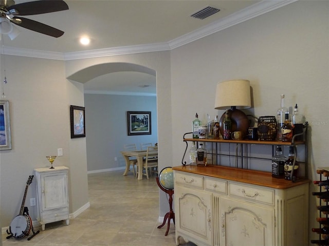 corridor featuring arched walkways, baseboards, visible vents, and crown molding