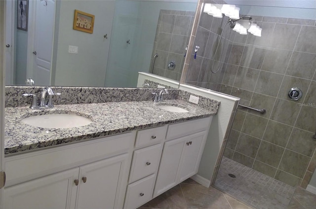 bathroom with tile patterned floors, double vanity, a sink, and walk in shower