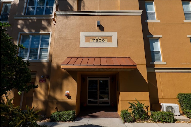 7500 Toscana Blvd Unit 341, Orlando, FL 32819 - entrance to property featuring a standing seam roof, ac unit, stucco siding, and metal roof