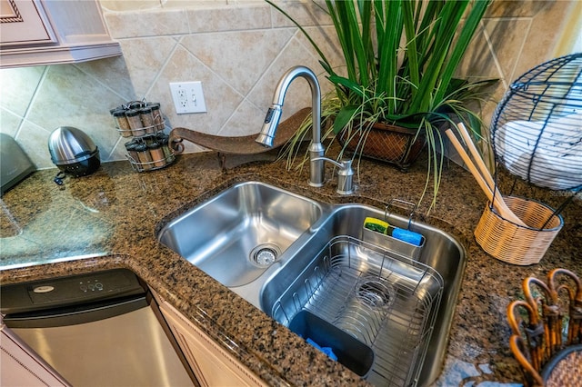 room details with decorative backsplash, dark stone counters, and sink