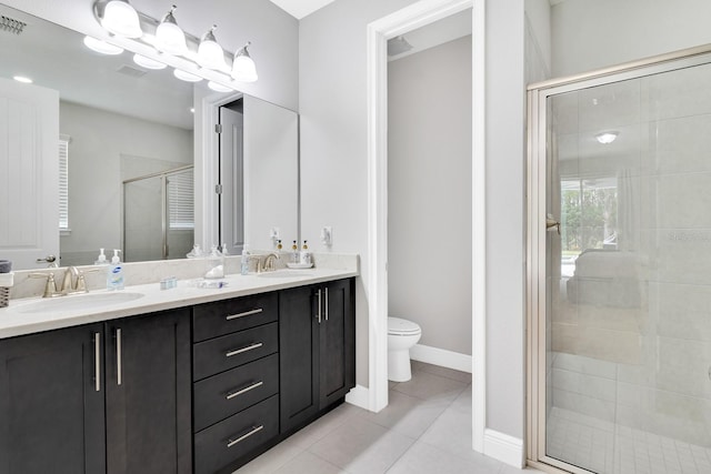 bathroom featuring toilet, vanity, tile patterned floors, and a shower with door