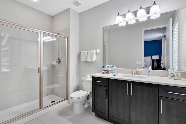 bathroom featuring tile patterned floors, a shower with door, vanity, and toilet