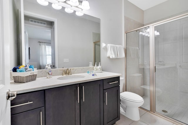 bathroom featuring tile patterned floors, vanity, toilet, and walk in shower