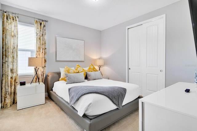 bedroom featuring light colored carpet and a closet