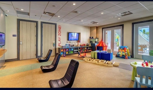 rec room with carpet floors and a drop ceiling