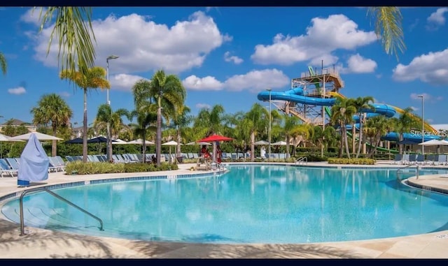 view of swimming pool with a patio and a water slide