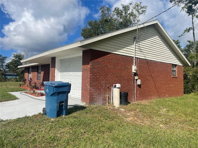 view of side of home with a yard and a garage