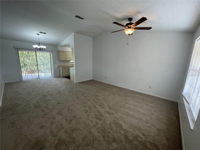 unfurnished living room with a textured ceiling, ceiling fan with notable chandelier, carpet floors, and lofted ceiling