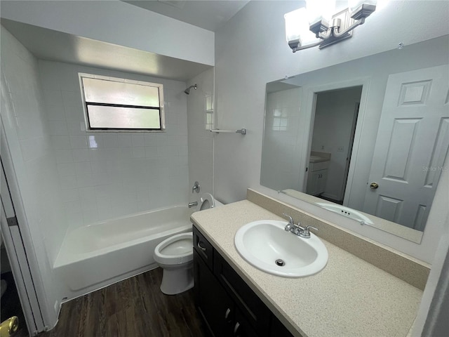 full bathroom with hardwood / wood-style floors, vanity, toilet, and tiled shower / bath