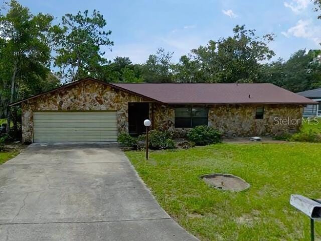 single story home featuring a front yard and a garage