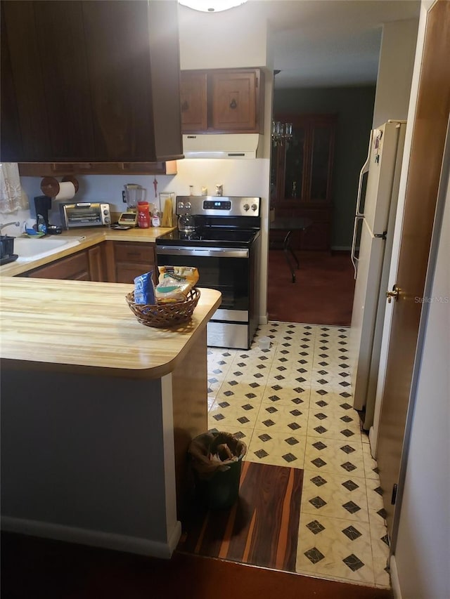 kitchen featuring kitchen peninsula, white refrigerator, stainless steel electric range oven, and sink