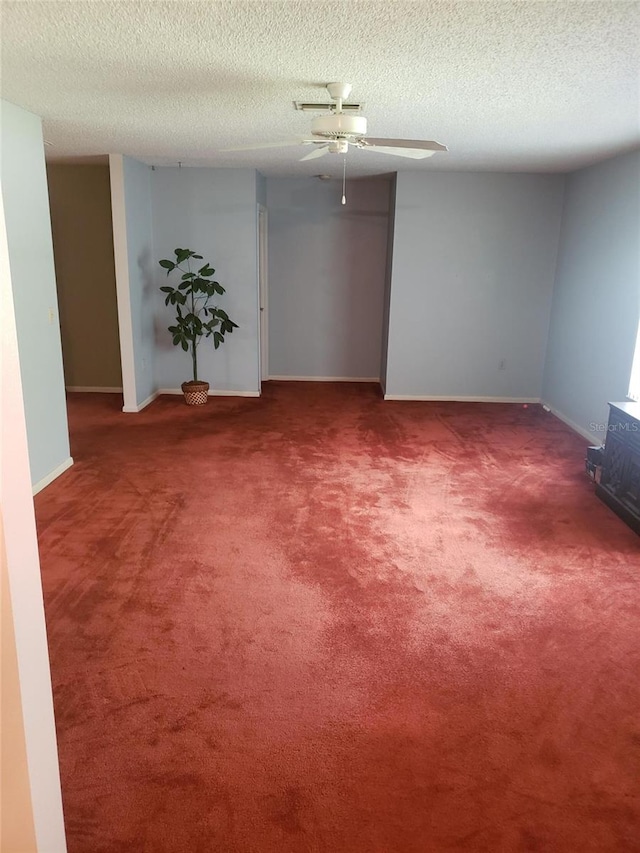 carpeted spare room featuring ceiling fan and a textured ceiling