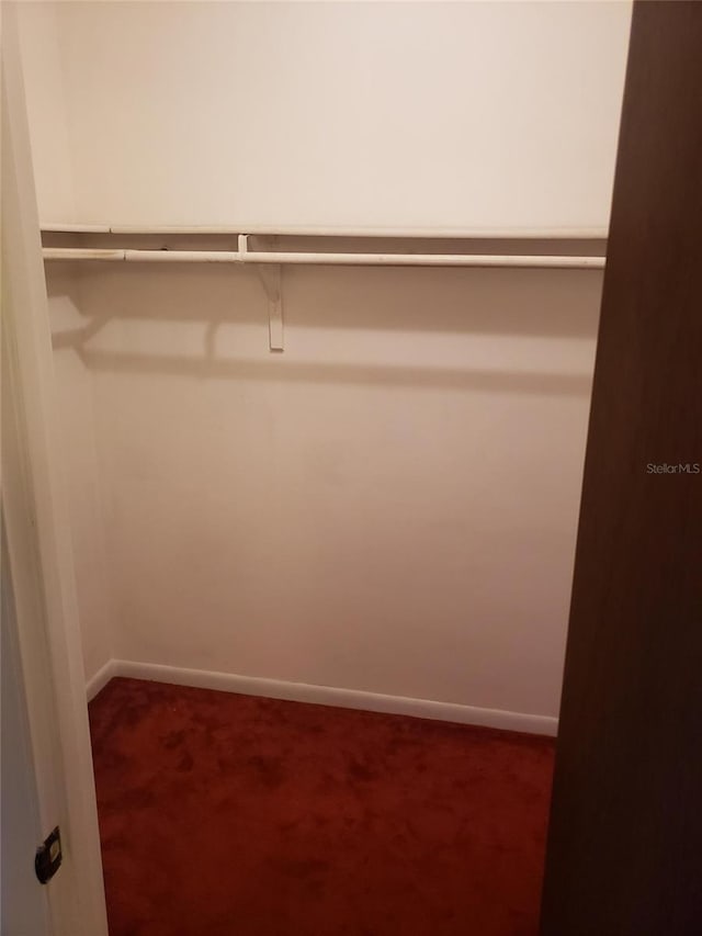 spacious closet featuring dark colored carpet