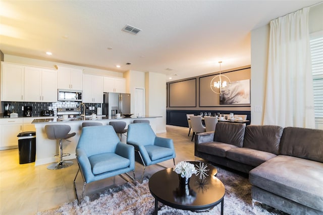 tiled living room featuring an inviting chandelier and sink