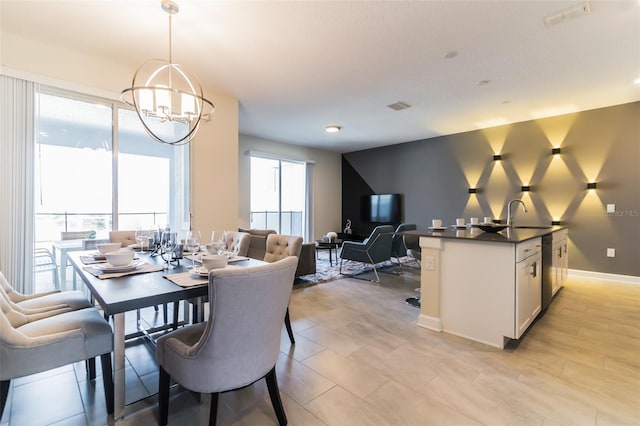 dining room with a wealth of natural light, sink, and an inviting chandelier