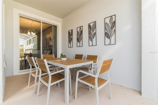 dining space with concrete floors and a notable chandelier