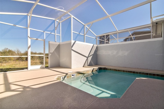 view of swimming pool featuring a patio area and a lanai