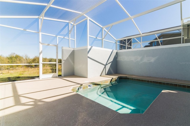 view of pool featuring glass enclosure and a patio area