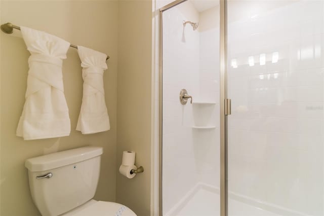 full bathroom featuring a stall shower and toilet