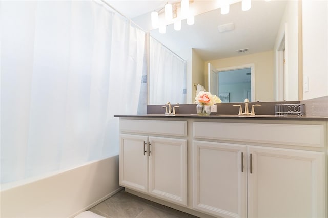bathroom with double vanity, shower / bath combo with shower curtain, and tile patterned flooring