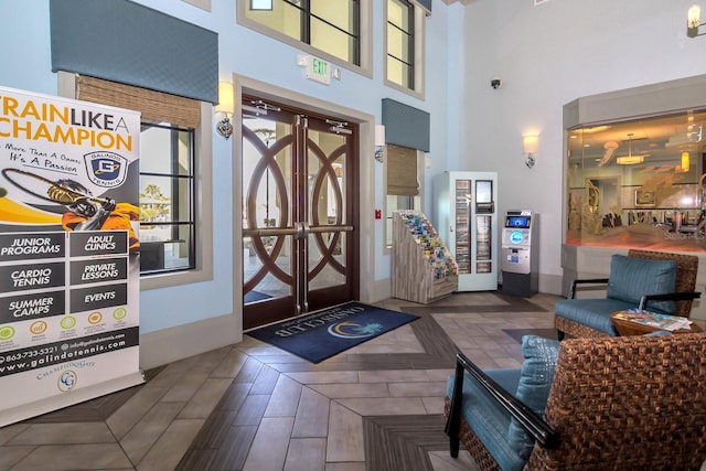 foyer entrance featuring a towering ceiling and french doors