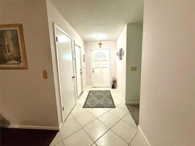 doorway with light tile patterned floors and a textured ceiling