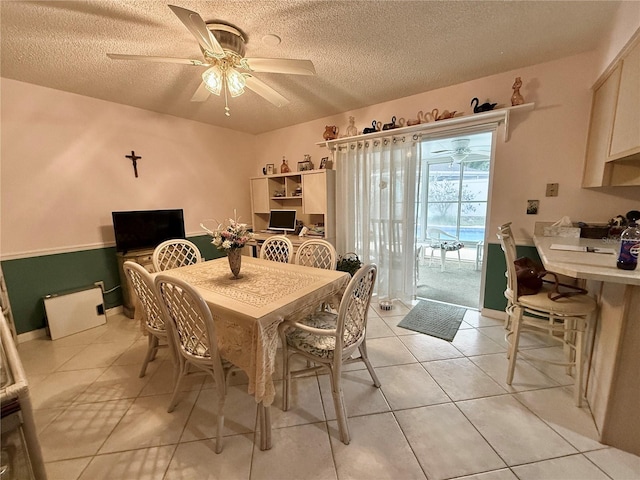 tiled dining area featuring ceiling fan and a textured ceiling