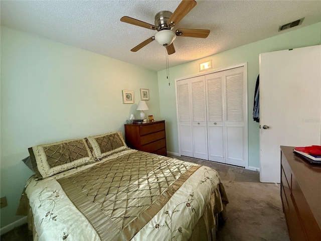 carpeted bedroom featuring a textured ceiling, a closet, and ceiling fan