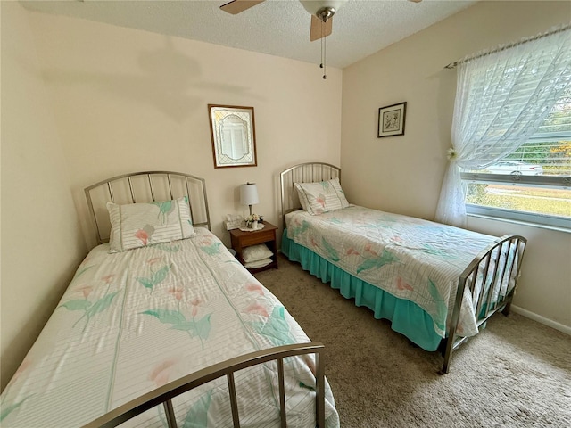 bedroom featuring dark colored carpet, ceiling fan, and a textured ceiling