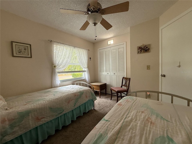 bedroom featuring dark colored carpet, ceiling fan, a textured ceiling, and a closet