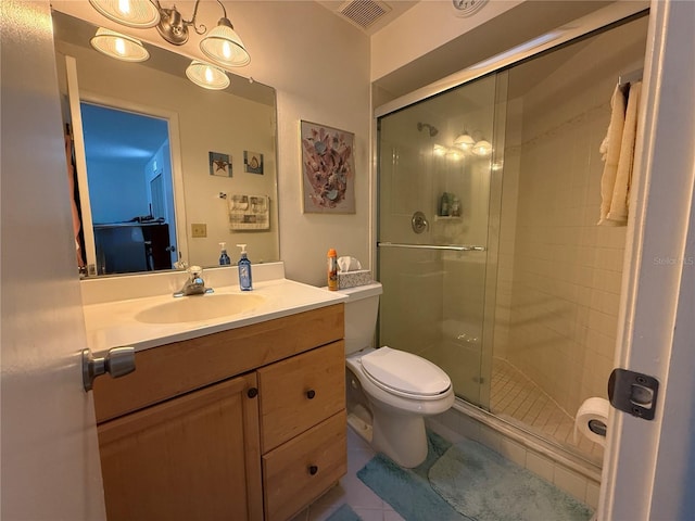 bathroom with tile patterned floors, vanity, an enclosed shower, and toilet