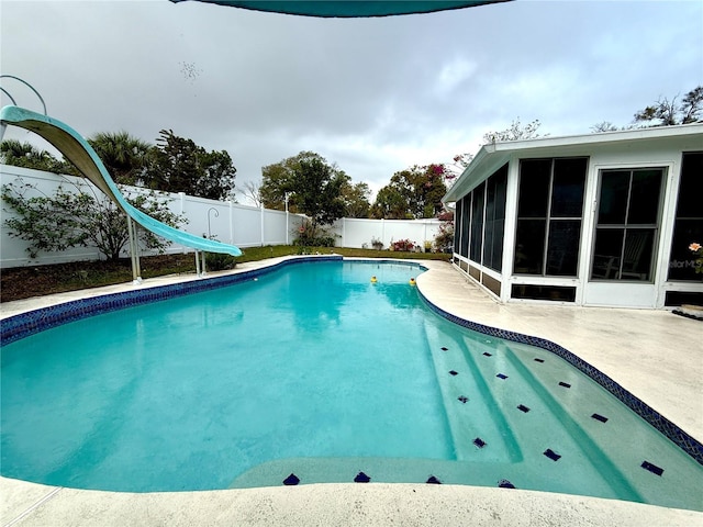 view of pool featuring a patio area, a sunroom, and a water slide