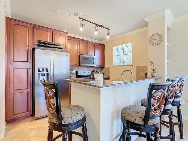 kitchen featuring decorative backsplash, dark stone countertops, ornamental molding, and stainless steel appliances