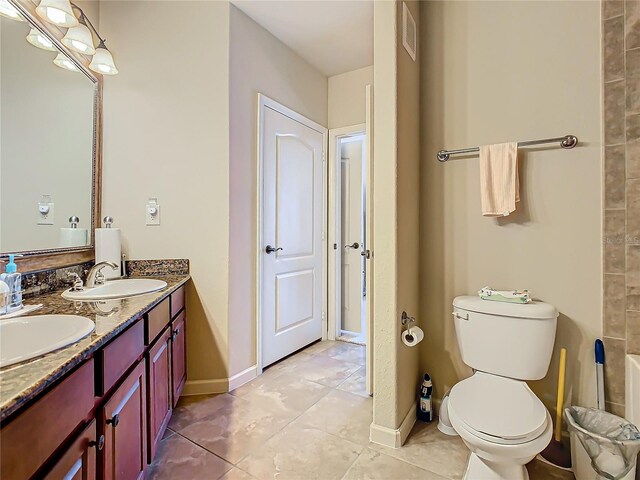 904 Charo Pkwy Unit 525, Davenport, FL 33897 - bathroom with double vanity, toilet, baseboards, and tile patterned flooring