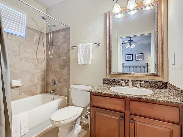 full bathroom featuring vanity, ceiling fan, toilet, and tiled shower / bath combo